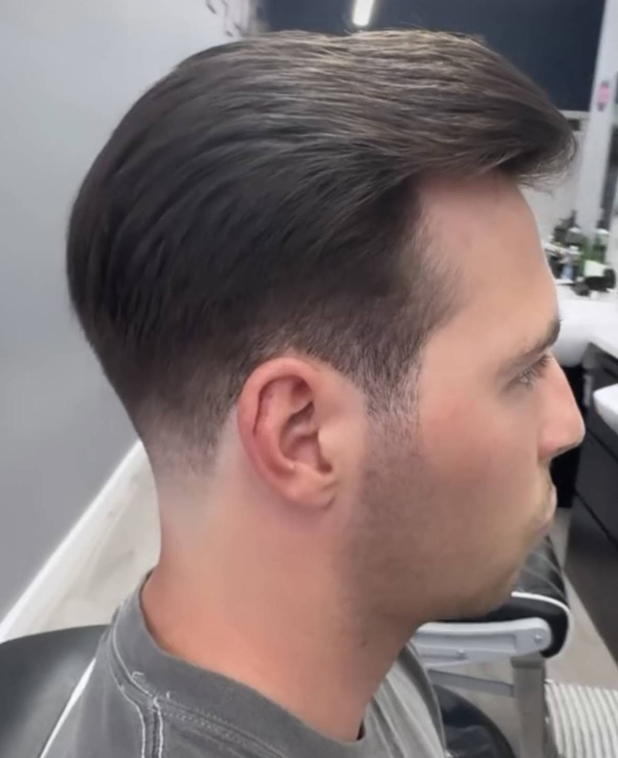 Slicked back cut with a tapered fade